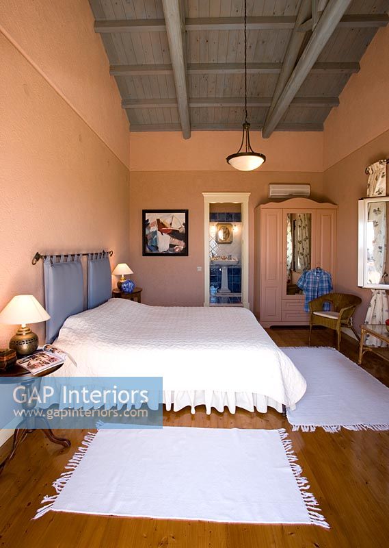 Corfu, Greece. Malama House near Barbati. Master bedroom with orange walls and wooden floor