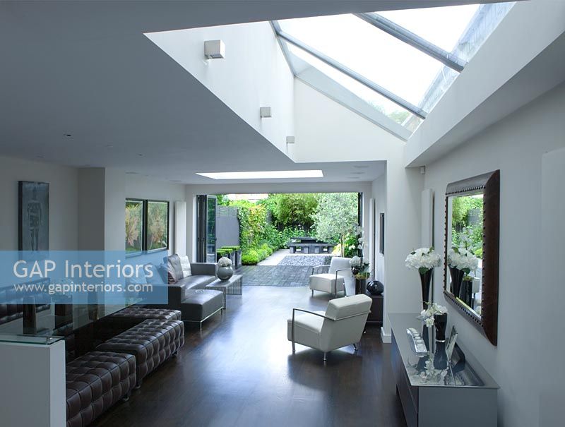 open plan  living and dining room with skylight and patio doors leading out onto contemporary garden designed by Charlotte Rowe