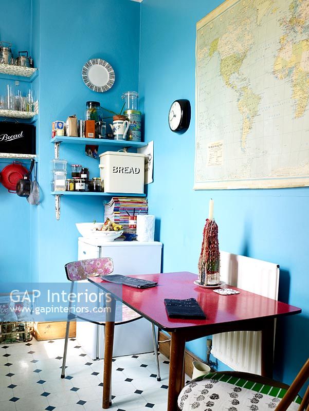 Quirky kitchen diner with blue painted walls and dining table and chairs