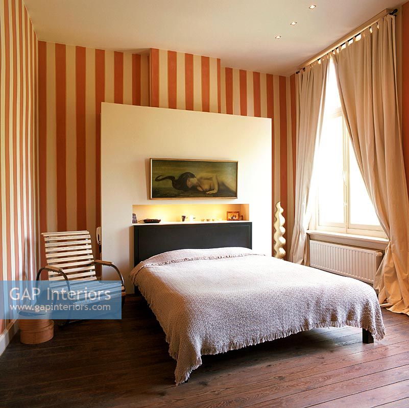 Spacious bedroom with striped wallpaper