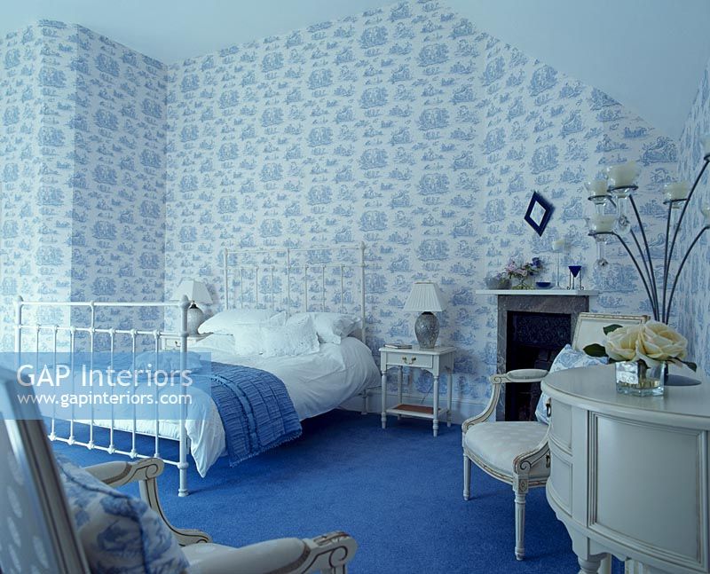 Bedroom with patterned wallpaper and blue carpet