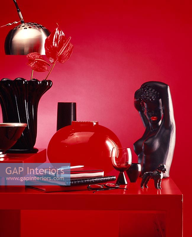 Red and black objects on side table