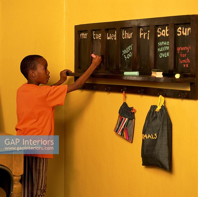 Young boy writing on a chalkboard