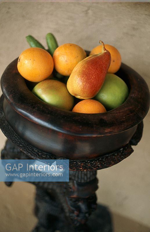 Ornate wooden bowl full of fruit