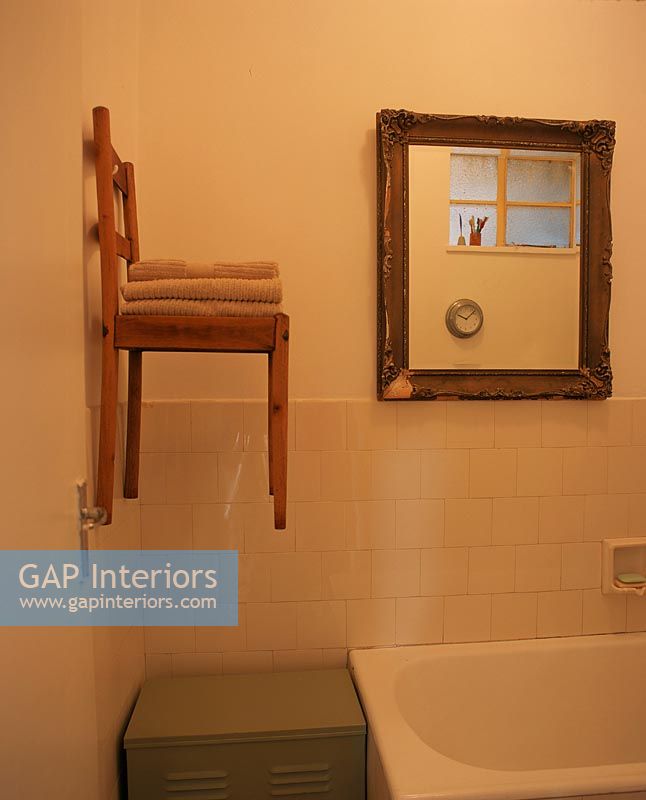 Bathroom with a chair hanging on the wall used as a shelf for towels