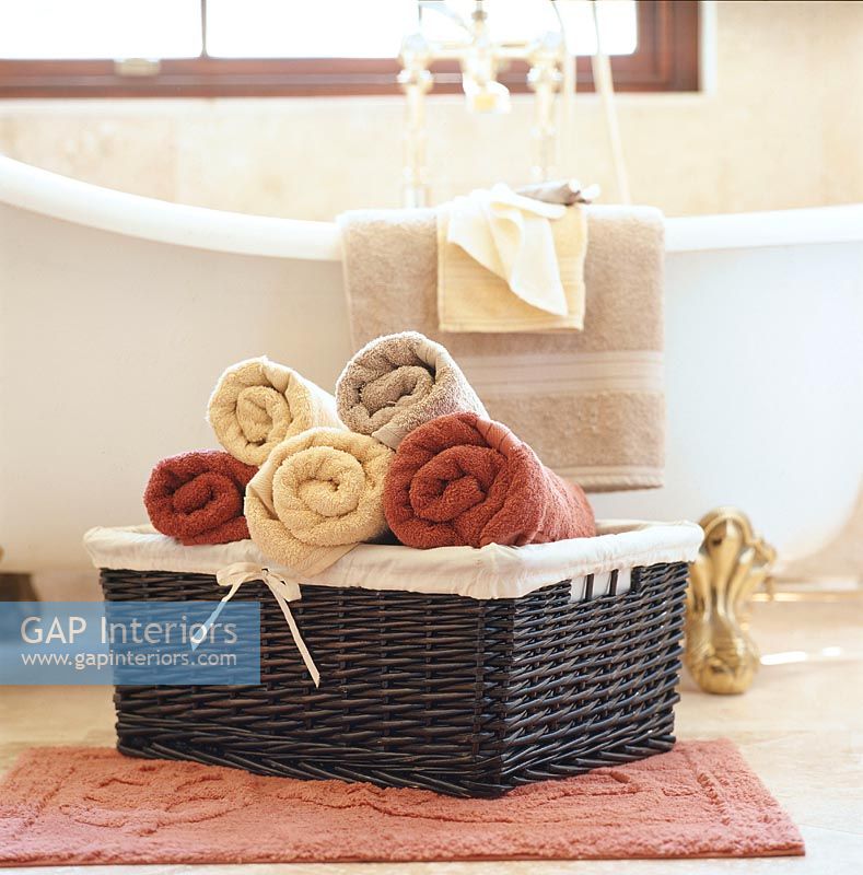 Towels in basket beside bath tub
