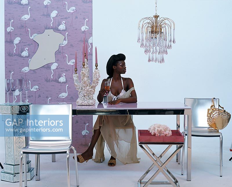 Woman sitting at a dining table with metallic chairs