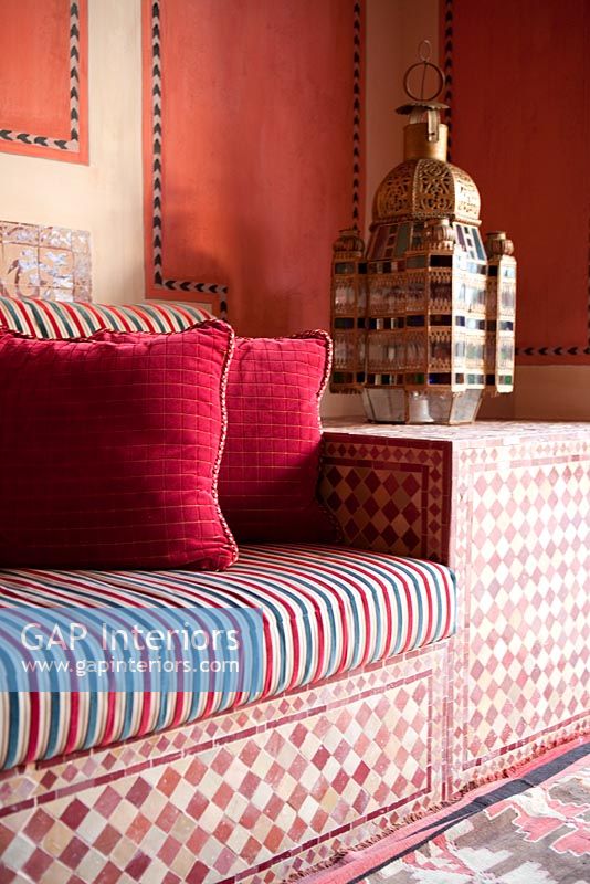 Detail of patterned moroccan sofa and brass lantern