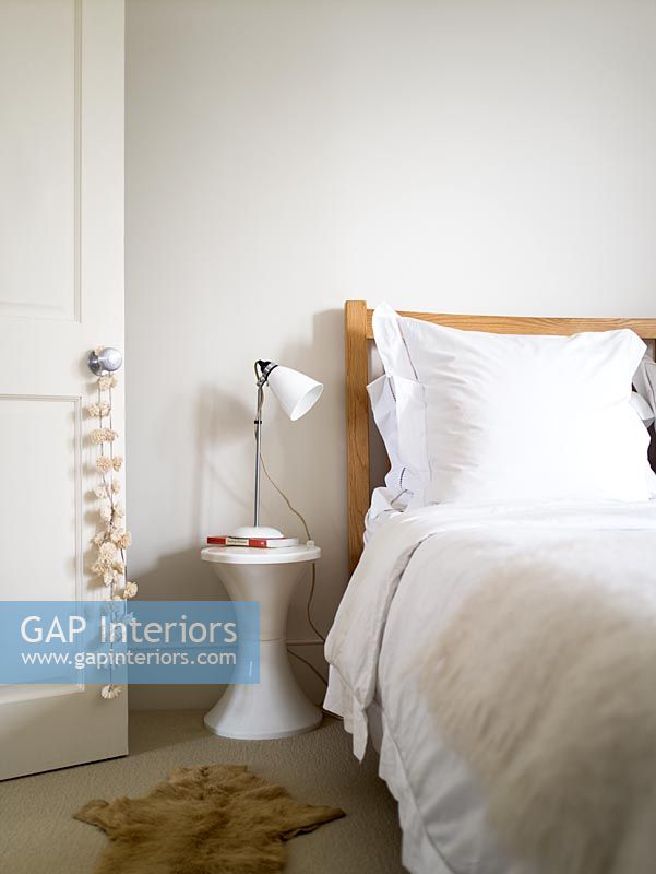 Contemporary white bedroom with Tam Tam stool used as bedside table