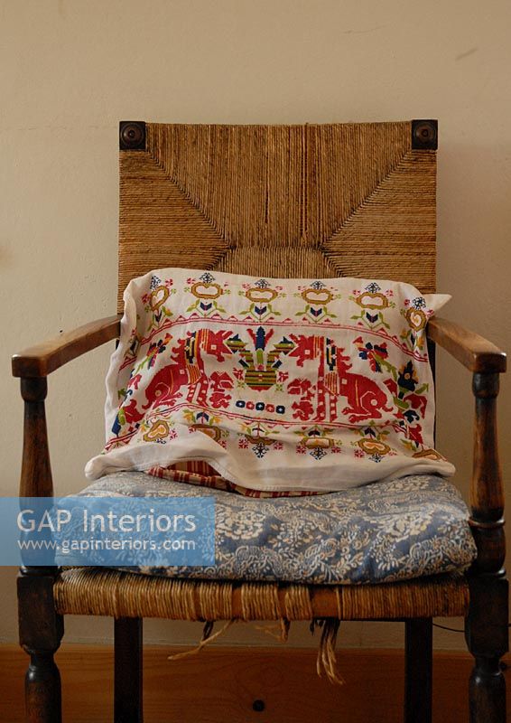 Embroidered cushion on country style chair