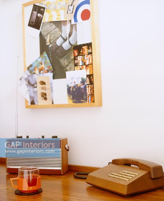 Retro radio, telephone and cup on sideboard