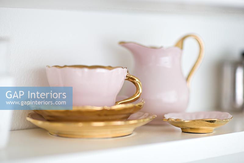 Pink and gold crockery set on shelf, detail