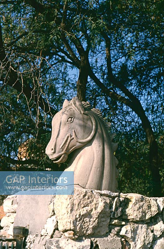 Statue of horse on exterior stone wall 