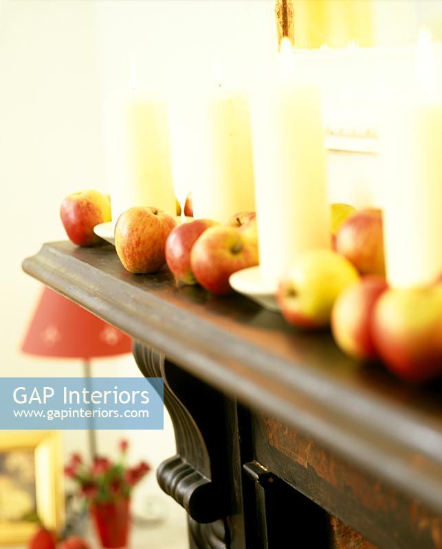 Display of apples and candles on mantelpiece 