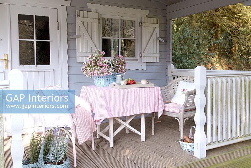 Garden table and chairs on summerhouse porch 