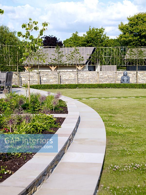 Curved raised beds in modern country garden 