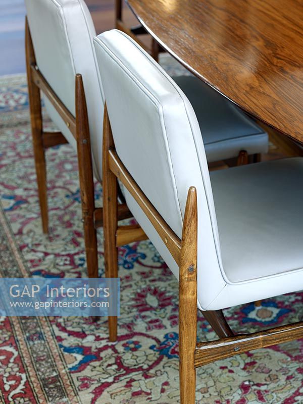 Detail of dining chairs on patterned rug 