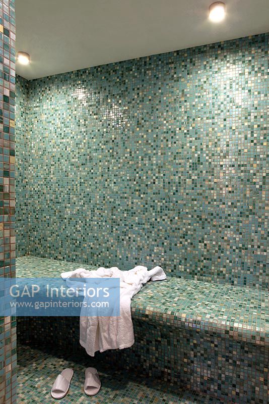 Green mosaic tiles covering steam room 