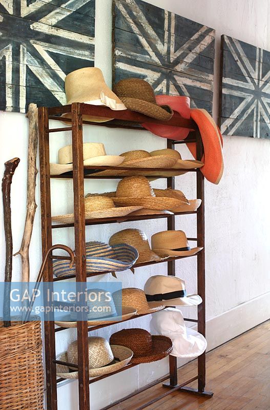 Collection of hats on hallway shelf unit 