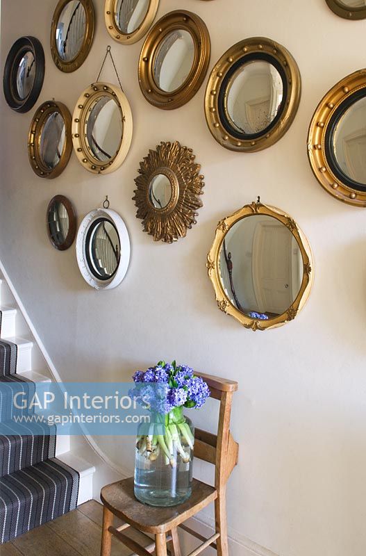 Display of vintage mirrors on hallway wall