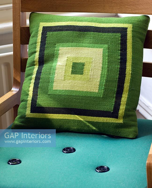 Green patterned cushion on blue chair 