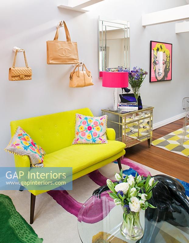 Open plan living room with designer handbags displayed on wall mounted hands
 