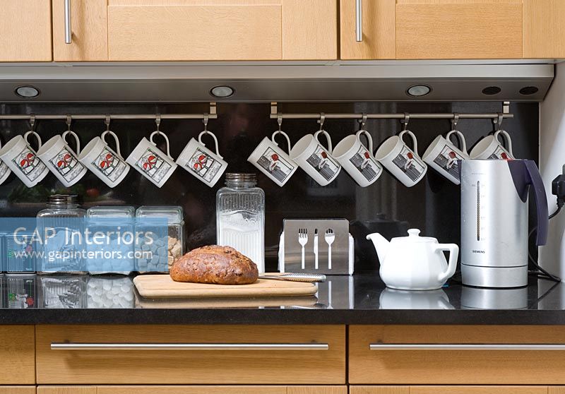 Mugs hanging from rail in kitchen