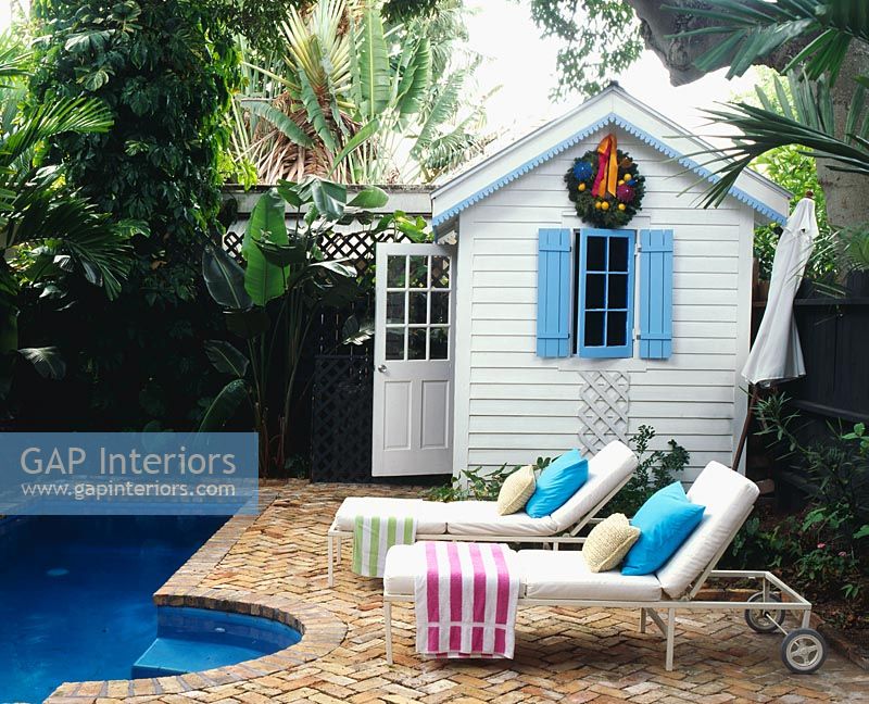 Loungers and summerhouse in tropical garden