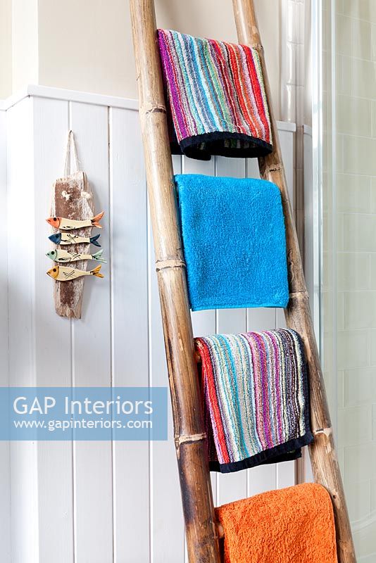 Colourful towels on bamboo rail