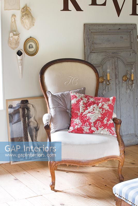 Reupholstered classic armchair with vintage floral cushion
