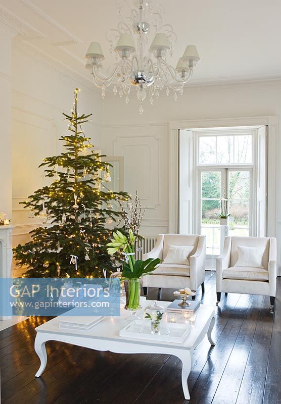 White living room with Christmas tree and presents