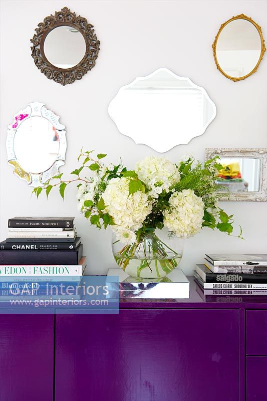 Mirrors displayed above purple sideboard