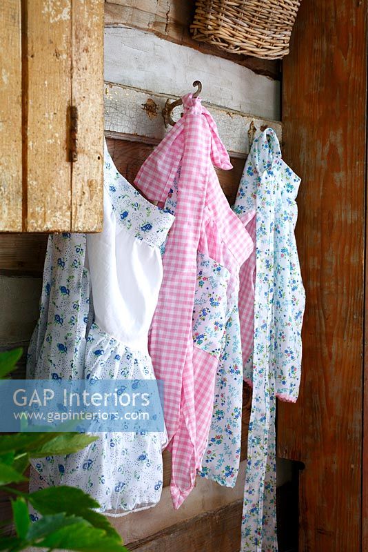 Floral aprons hanging from hooks