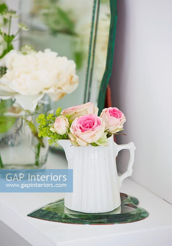Roses and Ladys mantle flowers in white jug