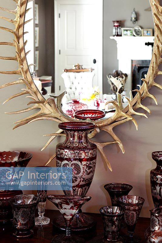 Glassware display under mirror with frame made of antlers