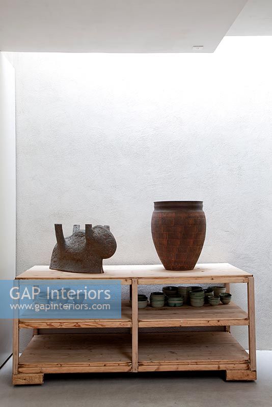 Ceramics by Cathérine Clarysse displayed on wooden shelves