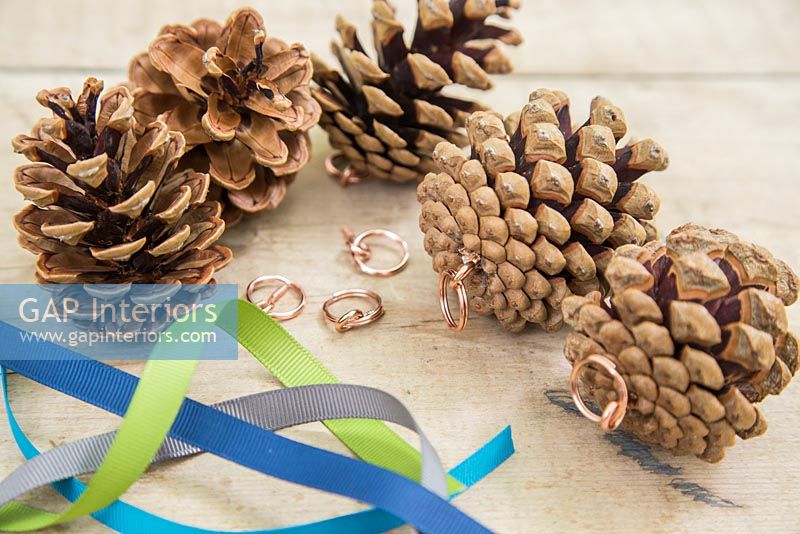Making christmas decorations with pine cones and ribbon