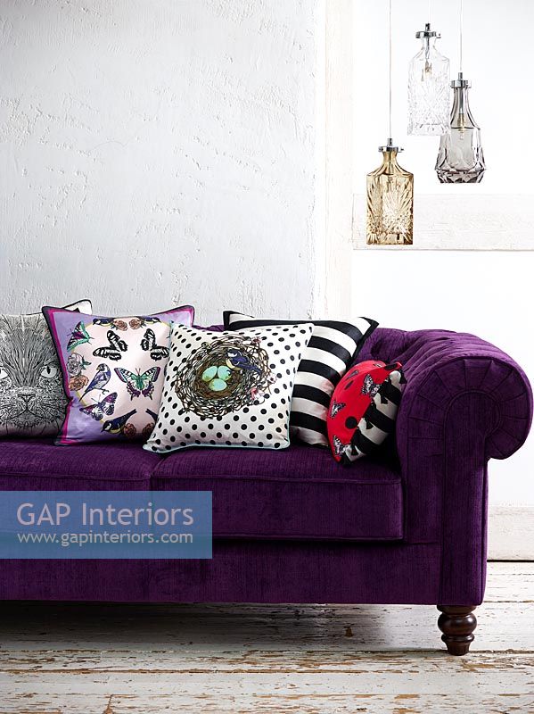 Colourful cushions on purple sofa