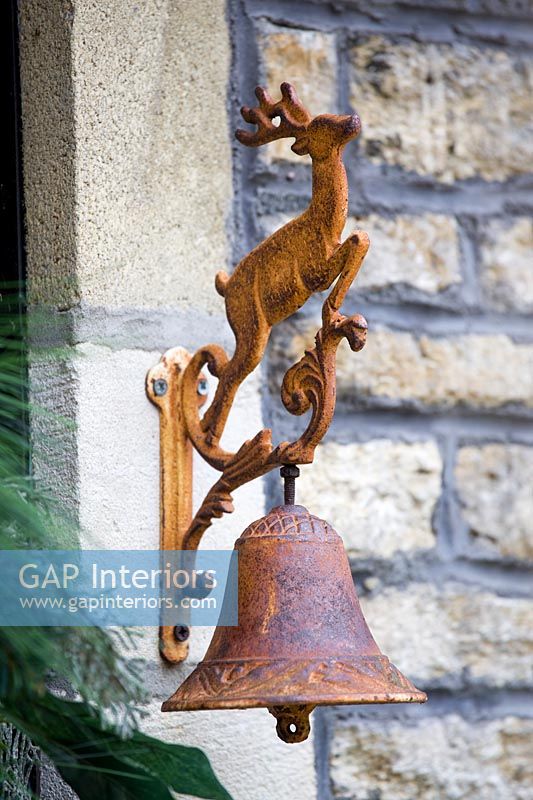 Rusty iron door bell with deer motif
