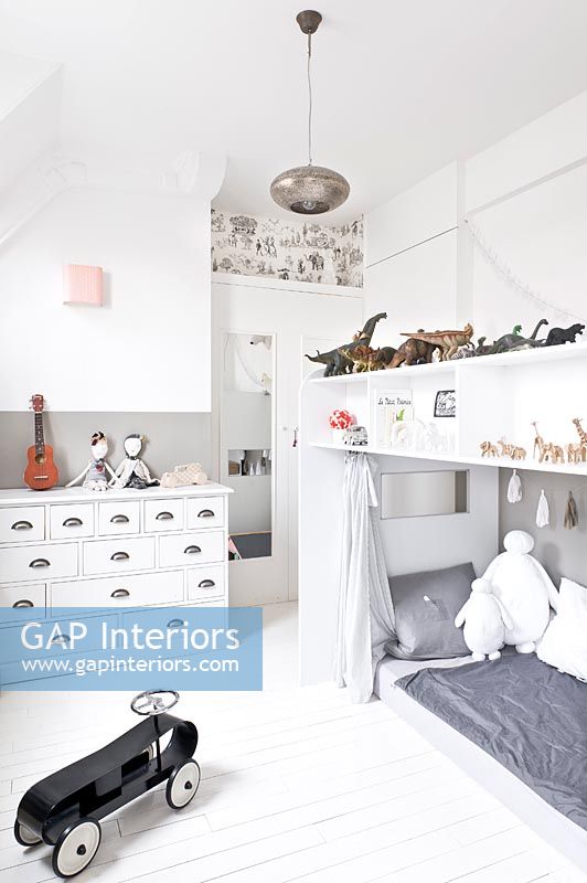White childs bedroom with storage above bed