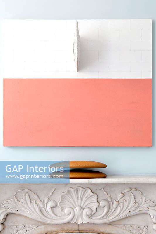 Abstract painting above ornate fireplace