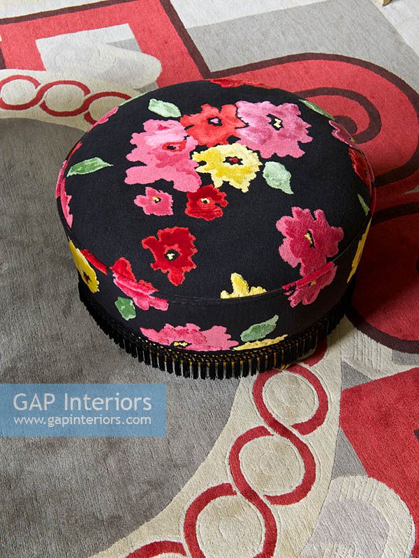 Floral ottoman on patterned rug