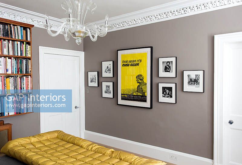 Framed posters and photos on bedroom wall