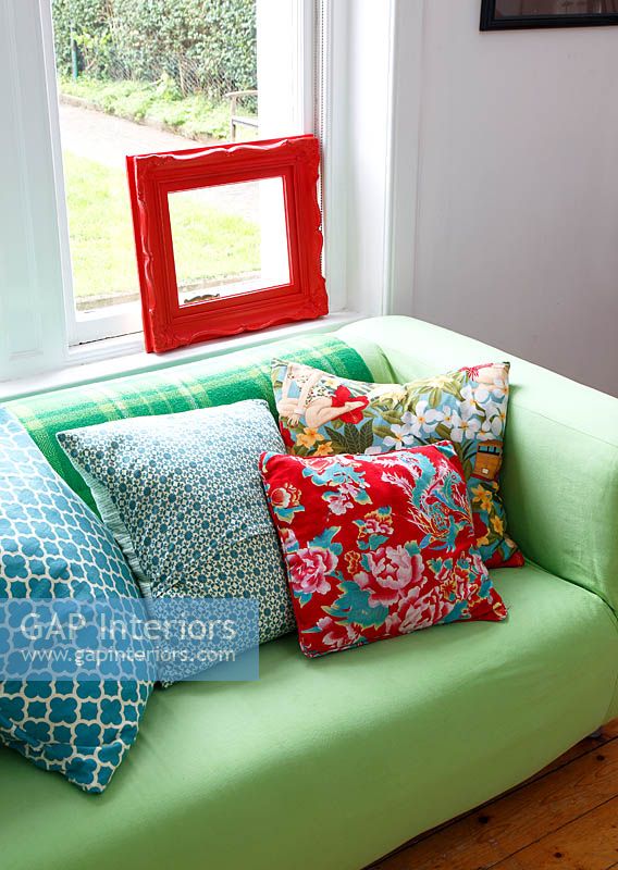 Patterned cushions on green sofa