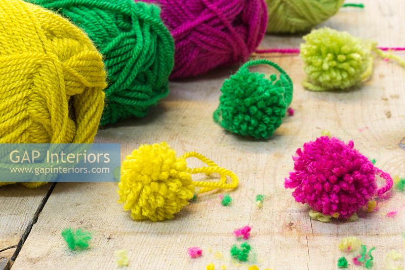Making christmas pompom decorations - A variety of finished pompoms in different colours 