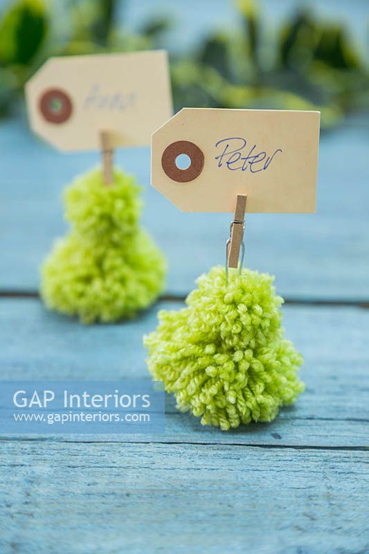 Miniature Christmas trees made from wool pompoms with place setting name cards 