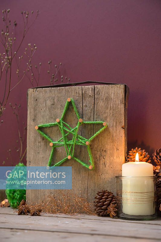 Making a christmas star decoration - A decorative plinth with a green woollen star wrapped around copper nails 