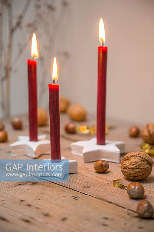 Red candles mounted inside clay stars, with hazlenuts and walnuts 