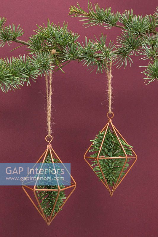 Copper prisms containing pine foliage, hanging from christmas tree
