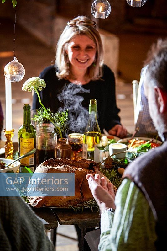 Man serving salt dough wrapped lamb at the decorated dining table 
